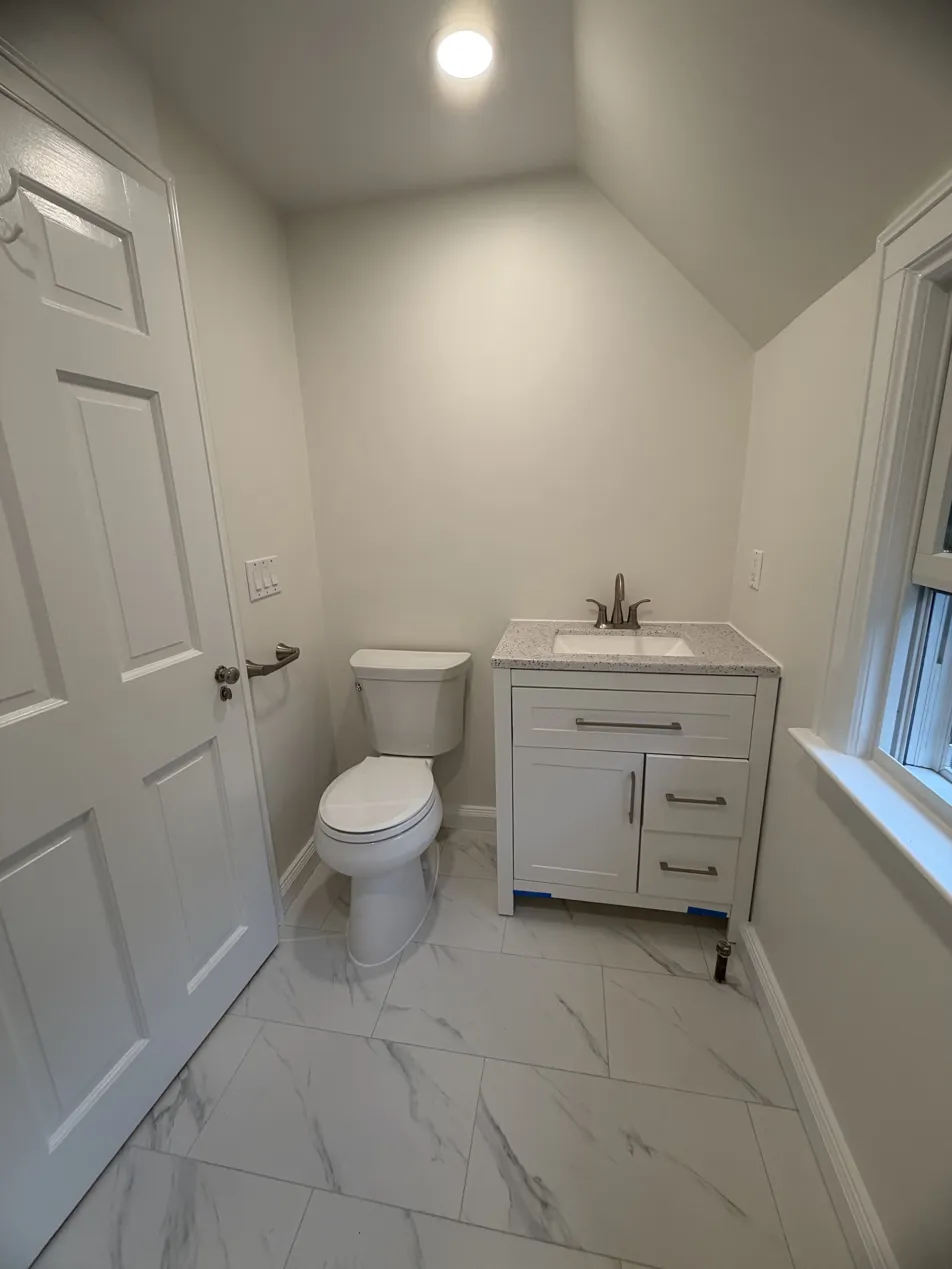 Completed guest bathroom showing window, finished marble floor and clean modern finishes