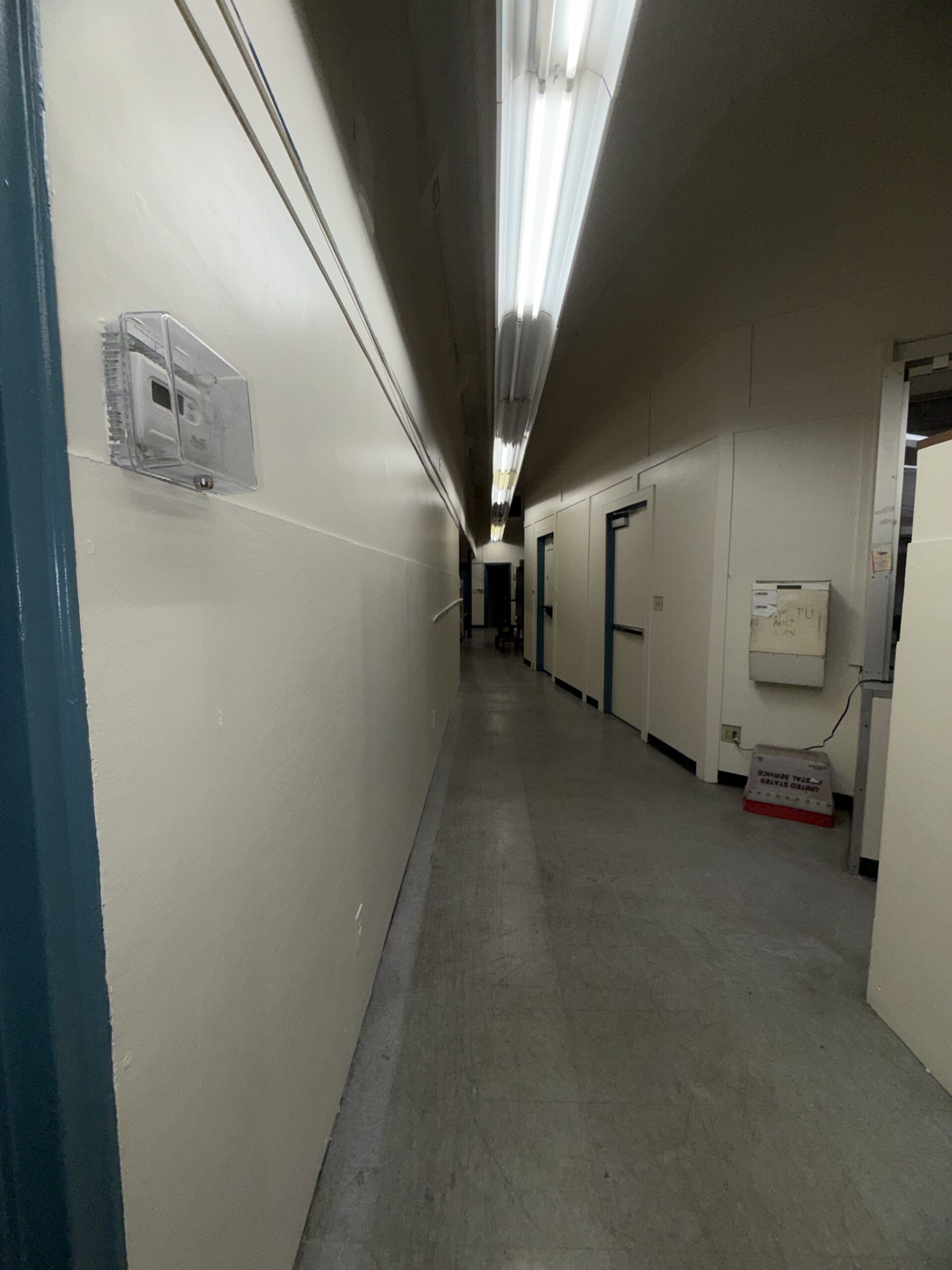 Freshly painted corridor in USPS facility, high-traffic finish