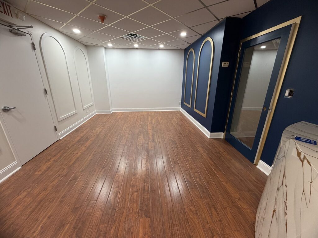 Dental office reception in Scarsdale NY with new front desk, arched wall panels and navy accent wall built by GCMM Dental Construction